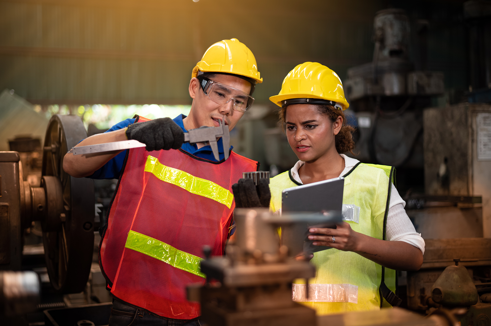 young workers in industrial plants work in front of the machine.
