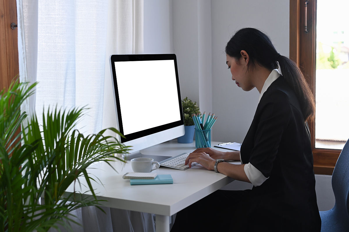 侧视图亚洲女性会计工作与电脑在办公室.
