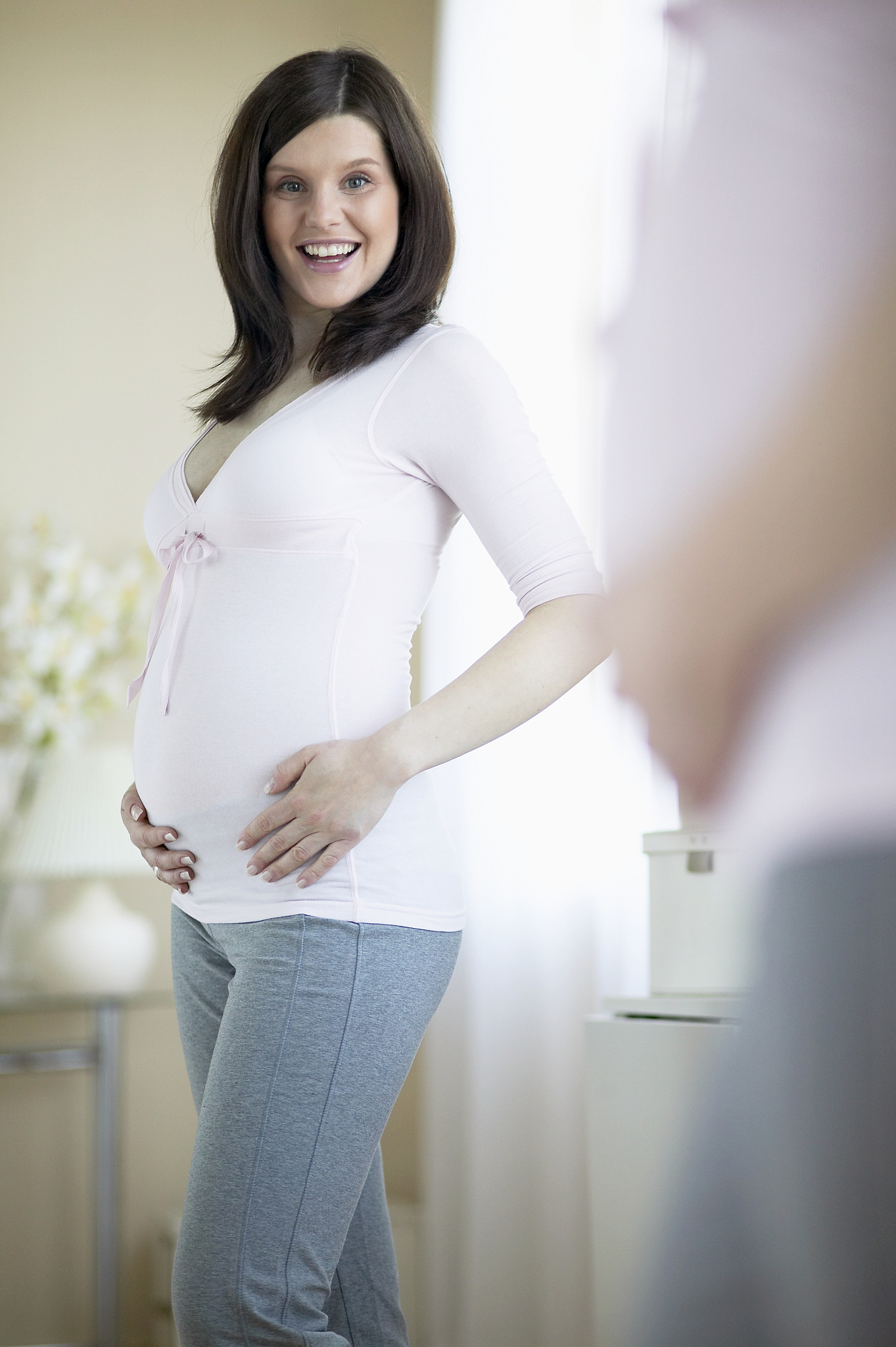 happy pregnant woman looking in mirror