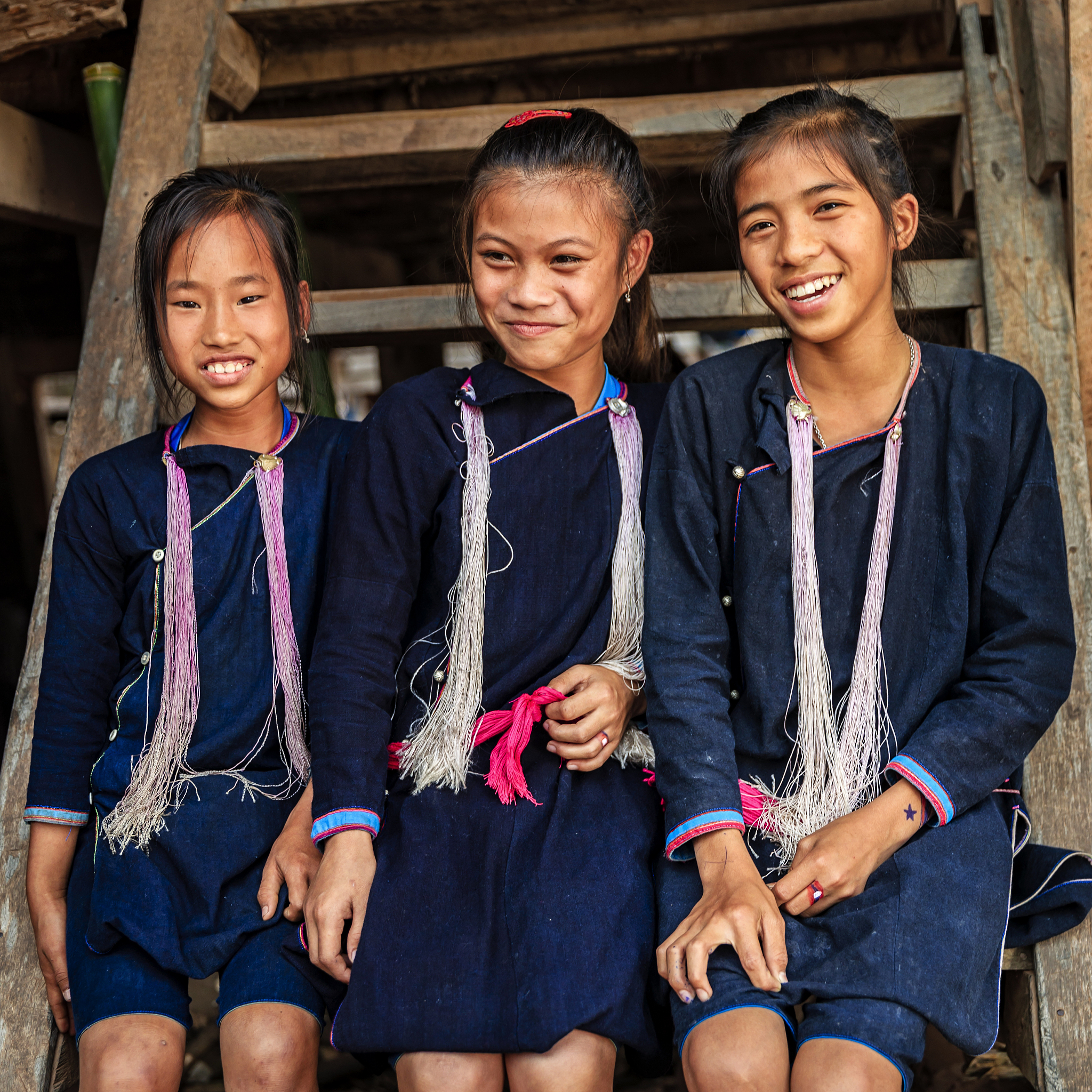 three laotian young girls in a village in northern laos