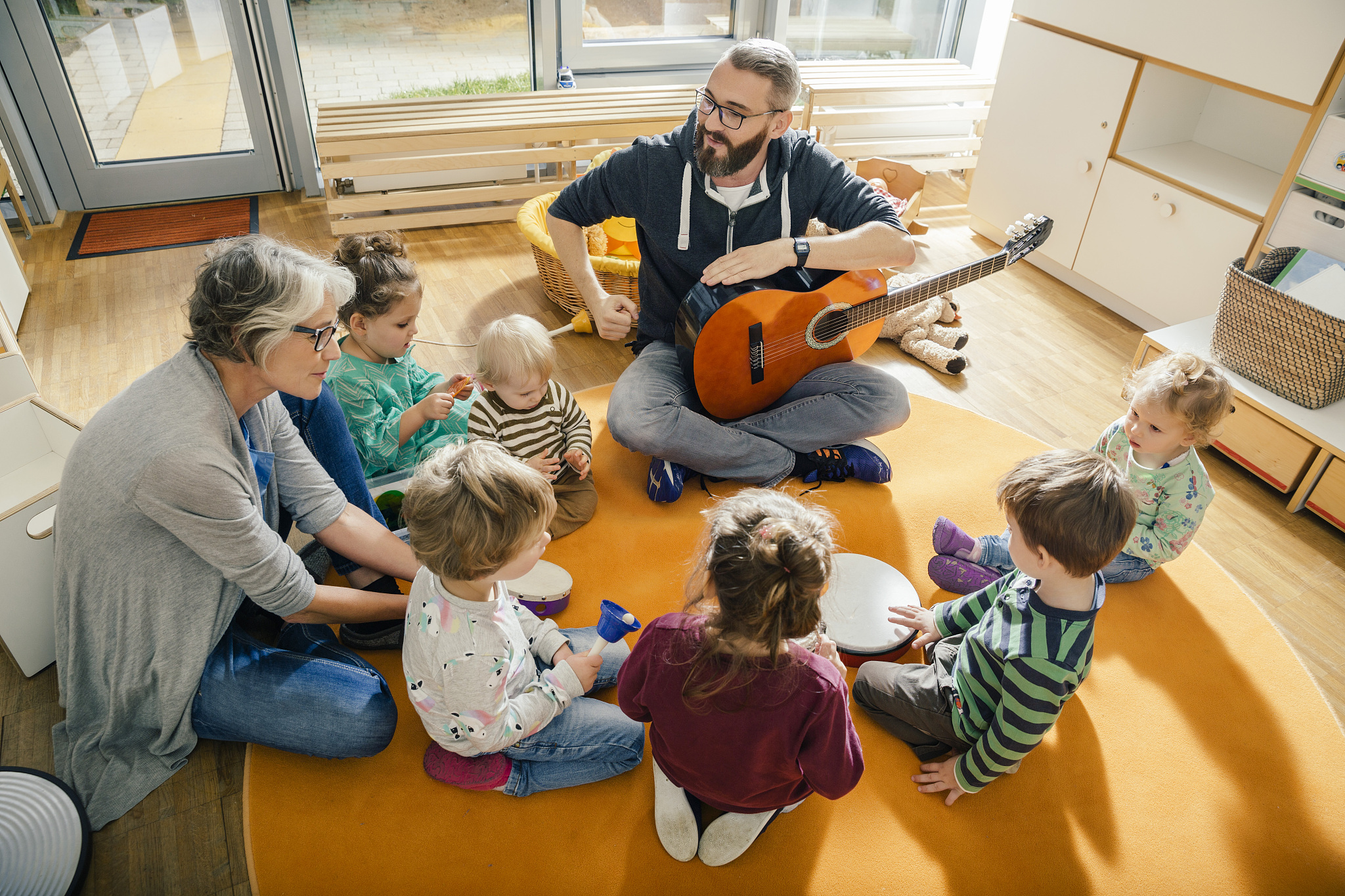 children and teachers singing and making music in kindergarten