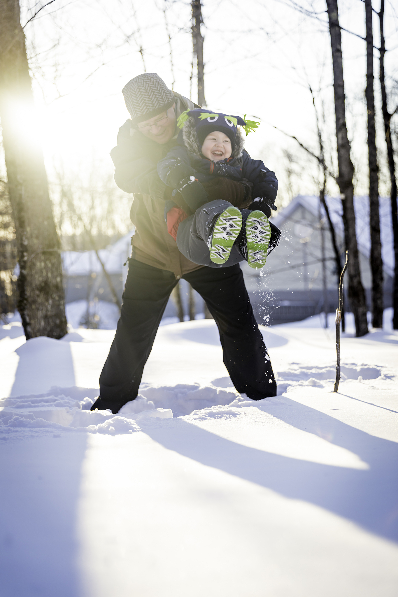 grandfather having fun with grandson outdoors in winter