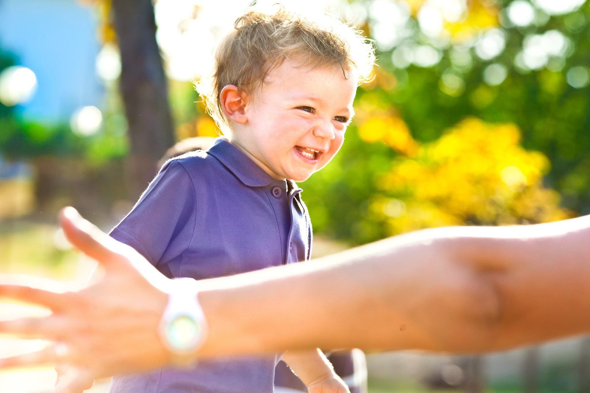 beautiful blond kid run toward his parent outdoor