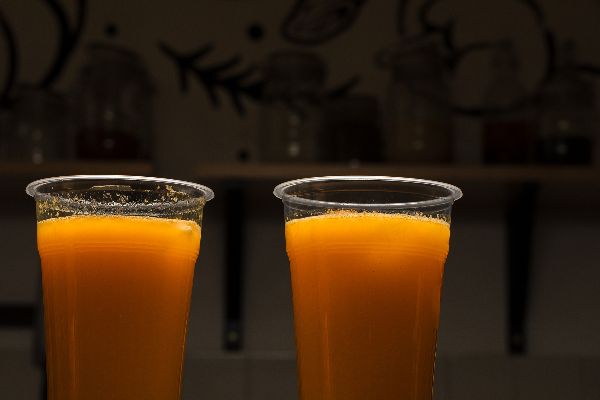 orange juice in two plastic drinking glasses, healthy drink back
