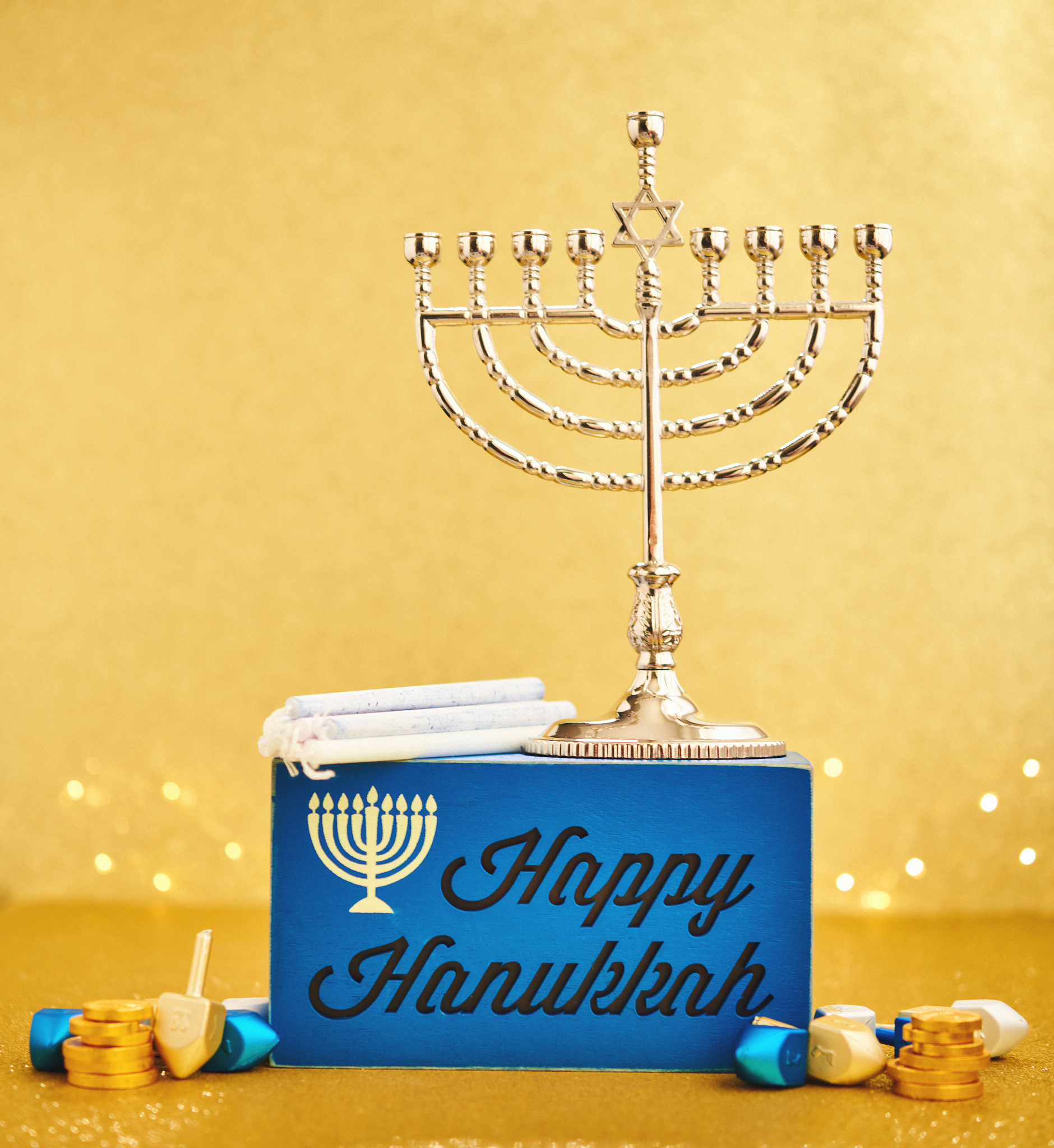 hanukkah background with menorah and dreidel on gold and happy h