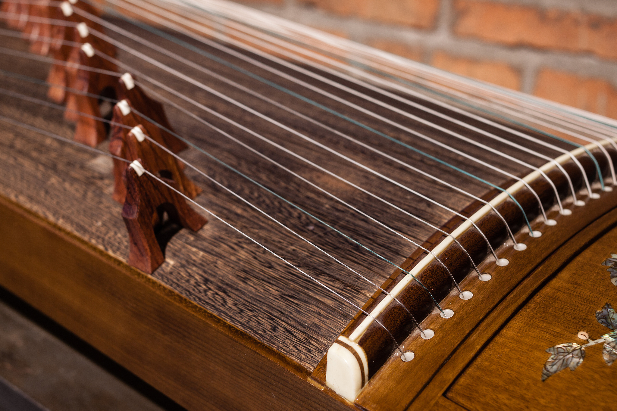 古筝是黑檀木 但是表面是泡桐木 我要怎么用专业的语言表达把这个古筝卖出去 要突出为什么有用泡桐木的作用用100字帮我描述