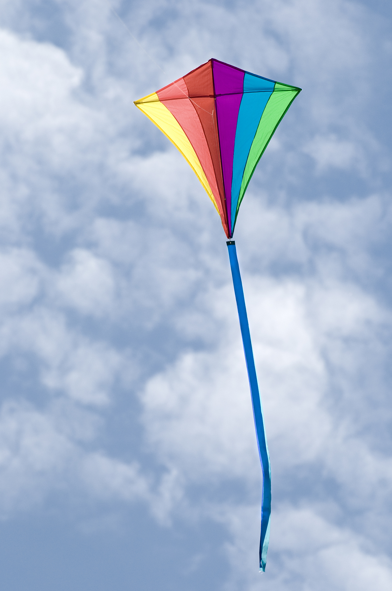 rainbow diamond kite on a cloudy sky