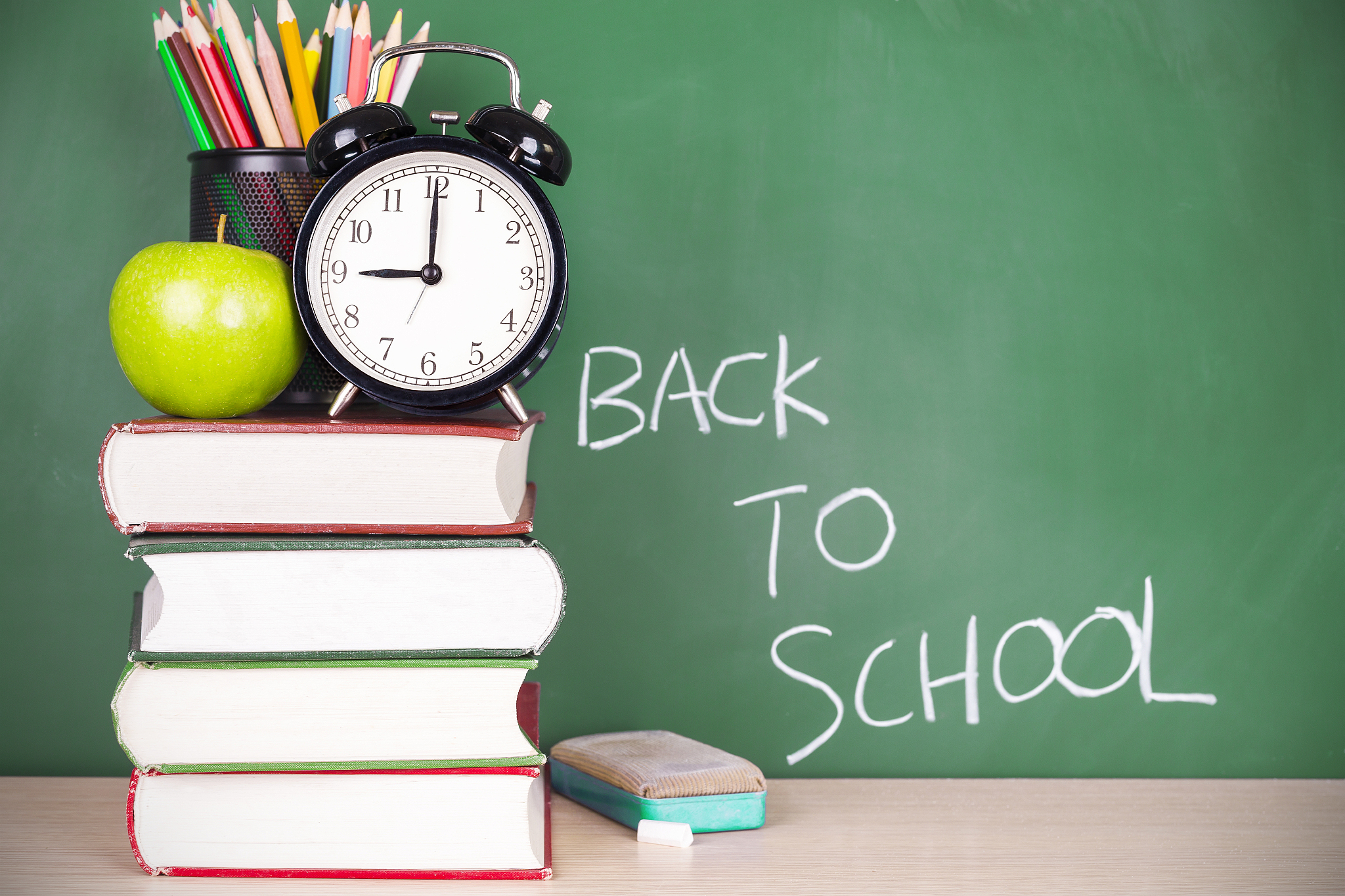 clock and book before blackboard