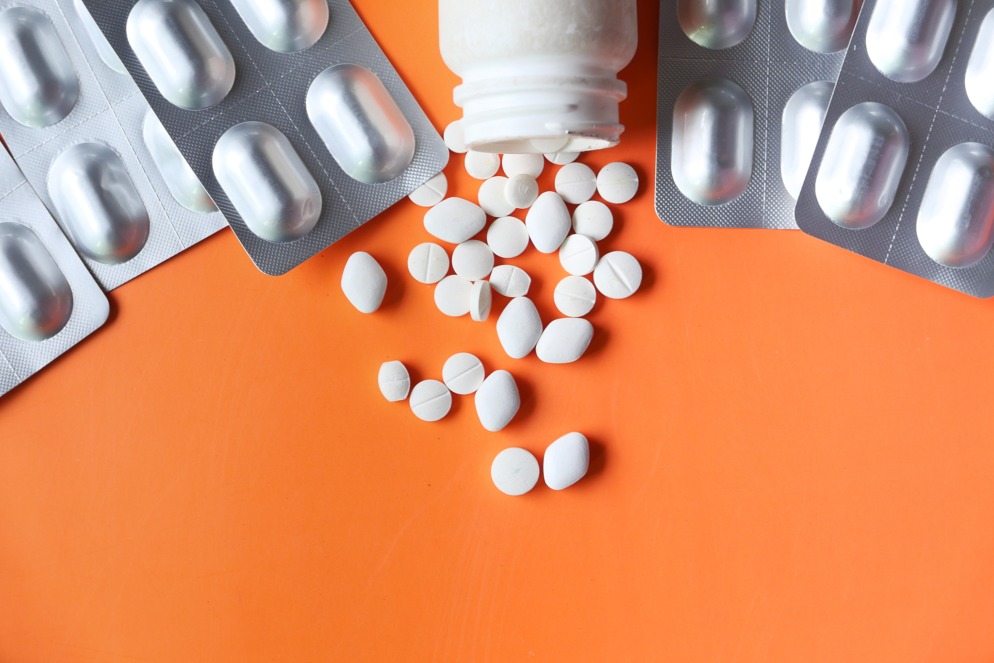 capsule, pills , container and blister pack on orange background
