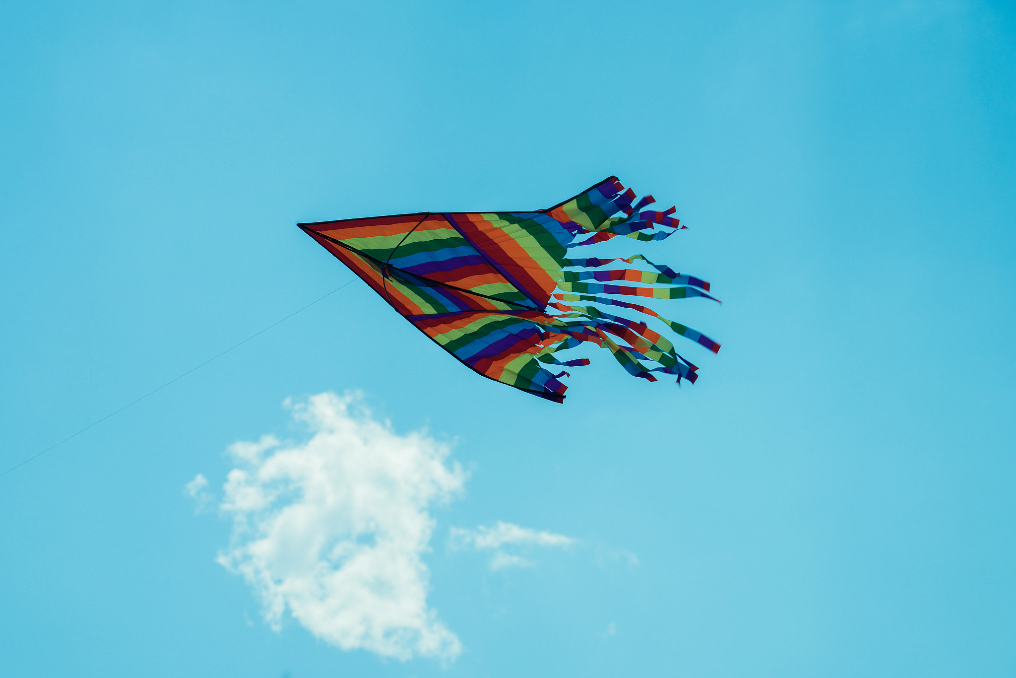 a kite flying in the blue sky against a background of clouds
