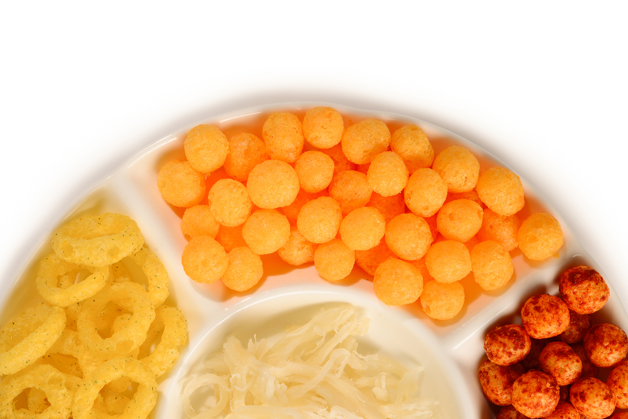 mix of snacks on a white plate isolated on white.