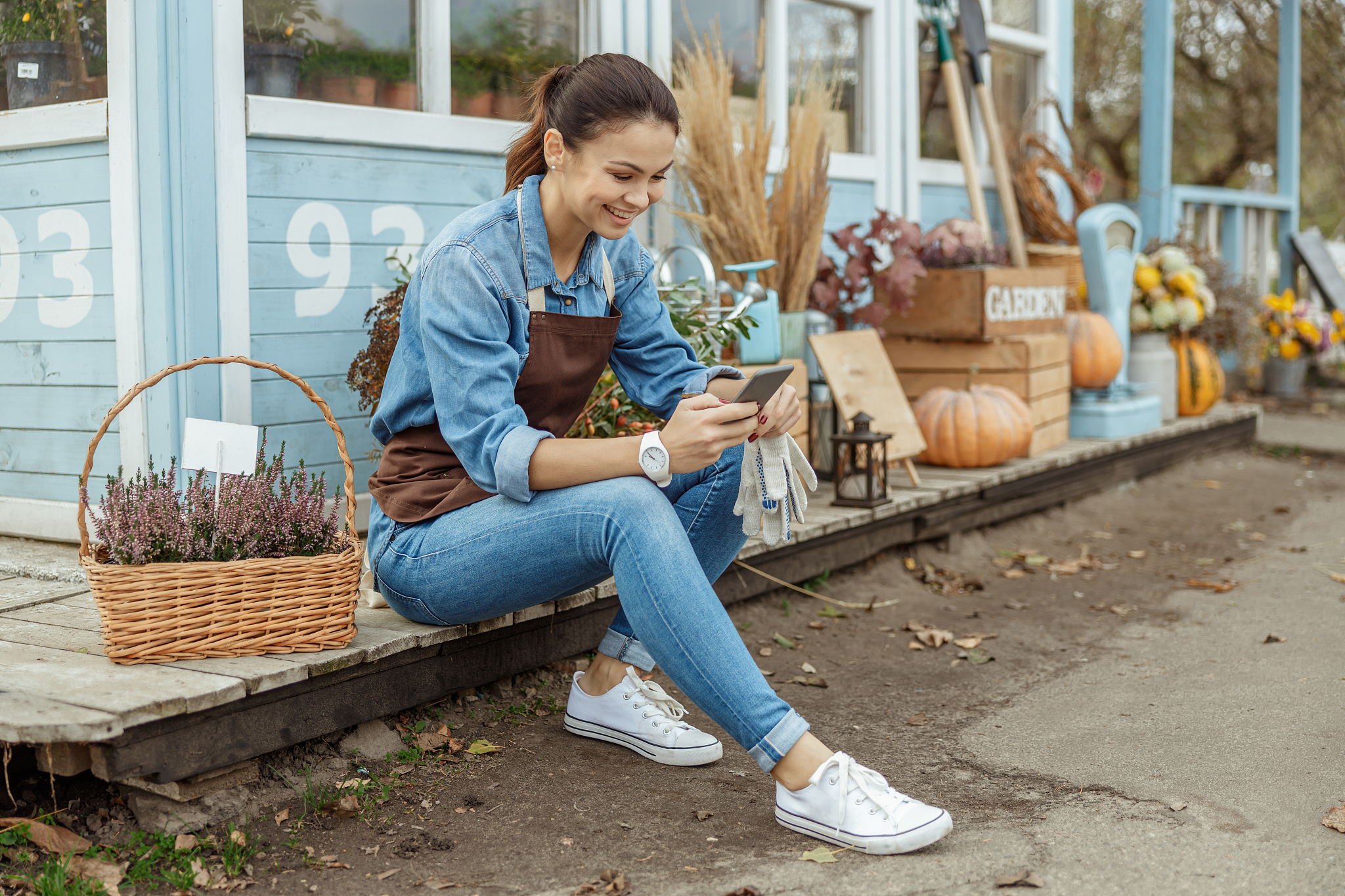 young woman with a gadget sitting outdoors