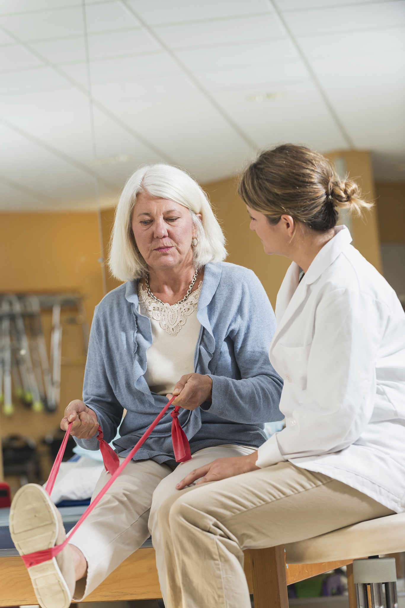 physical therapist halping mature woman with injured leg