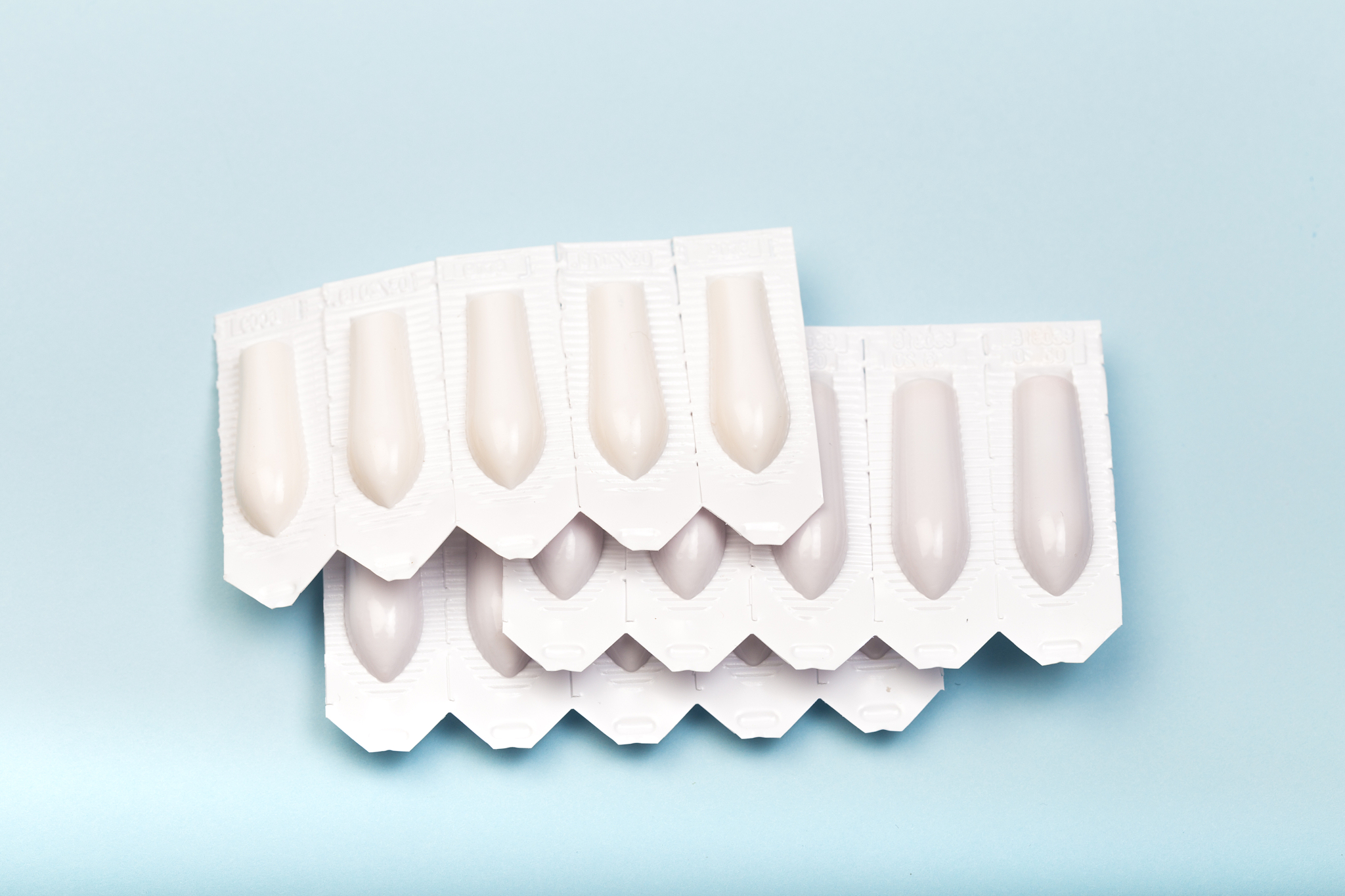 plastic packs of suppositories on blue  background - image
