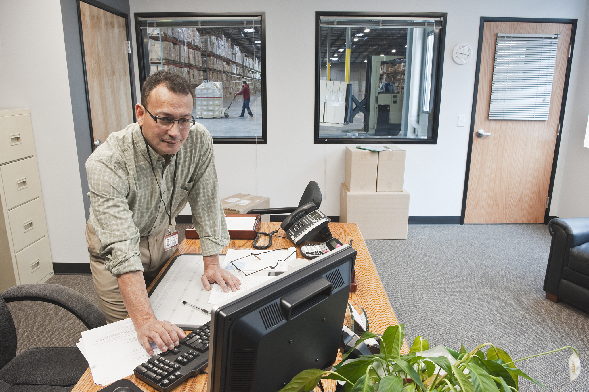 hispanic man using computer in warehouse office