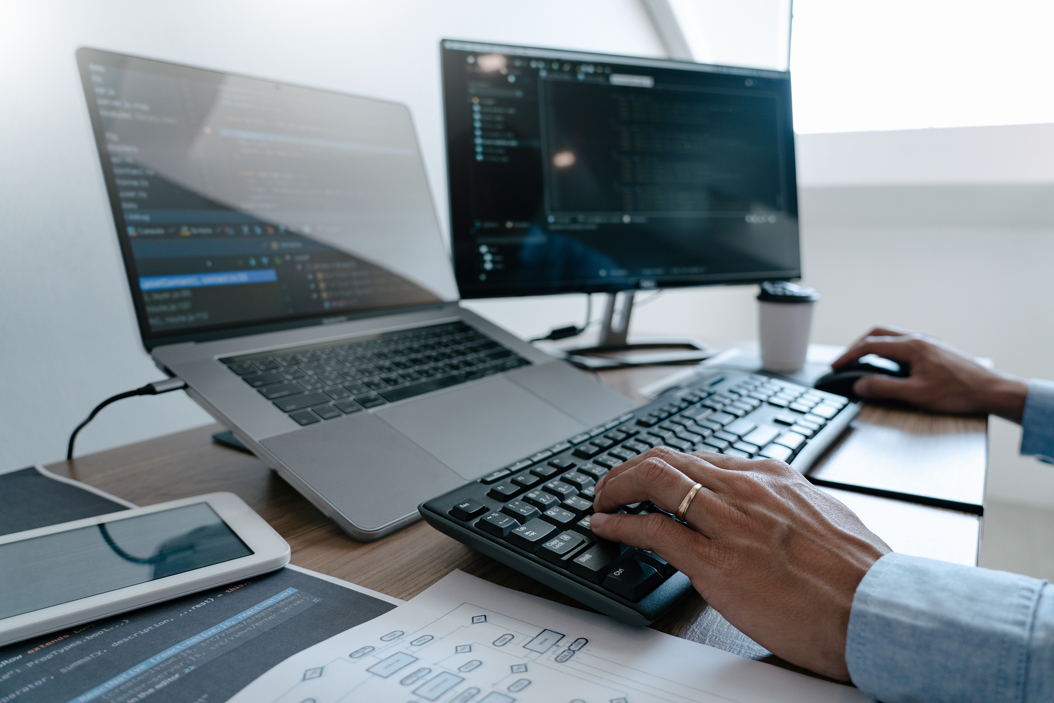 programmer typing code on desktop computer, developing programmi