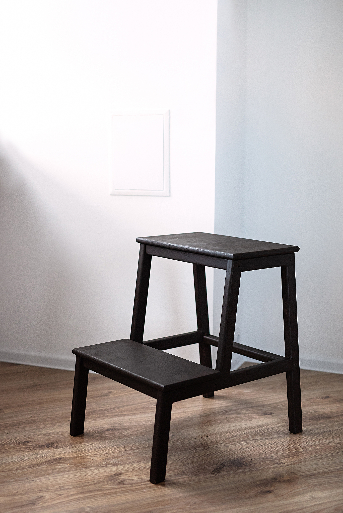 handmade wood furniture , a brown wood step ladder stands in a r