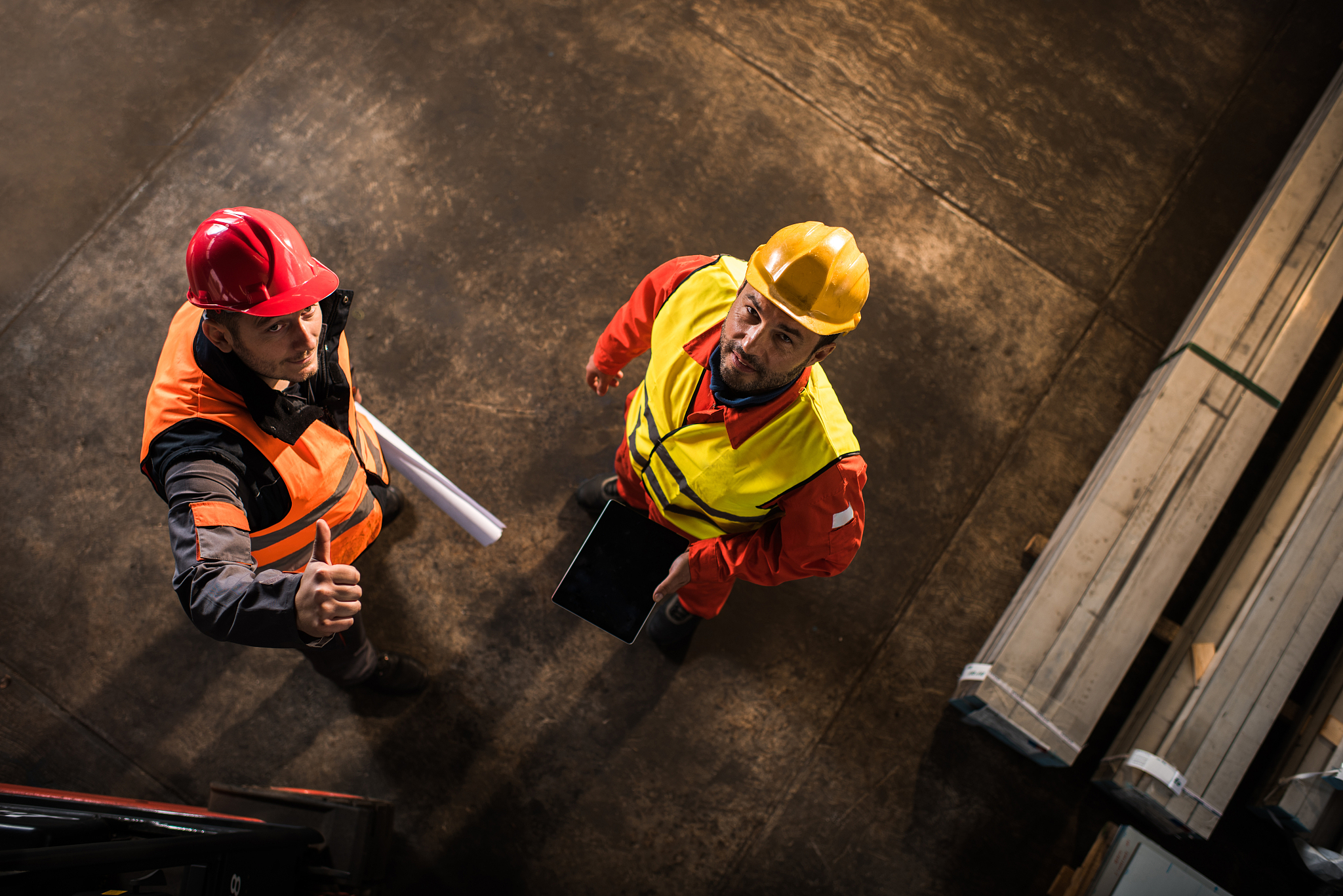 above view of two workers standing in industrial building.