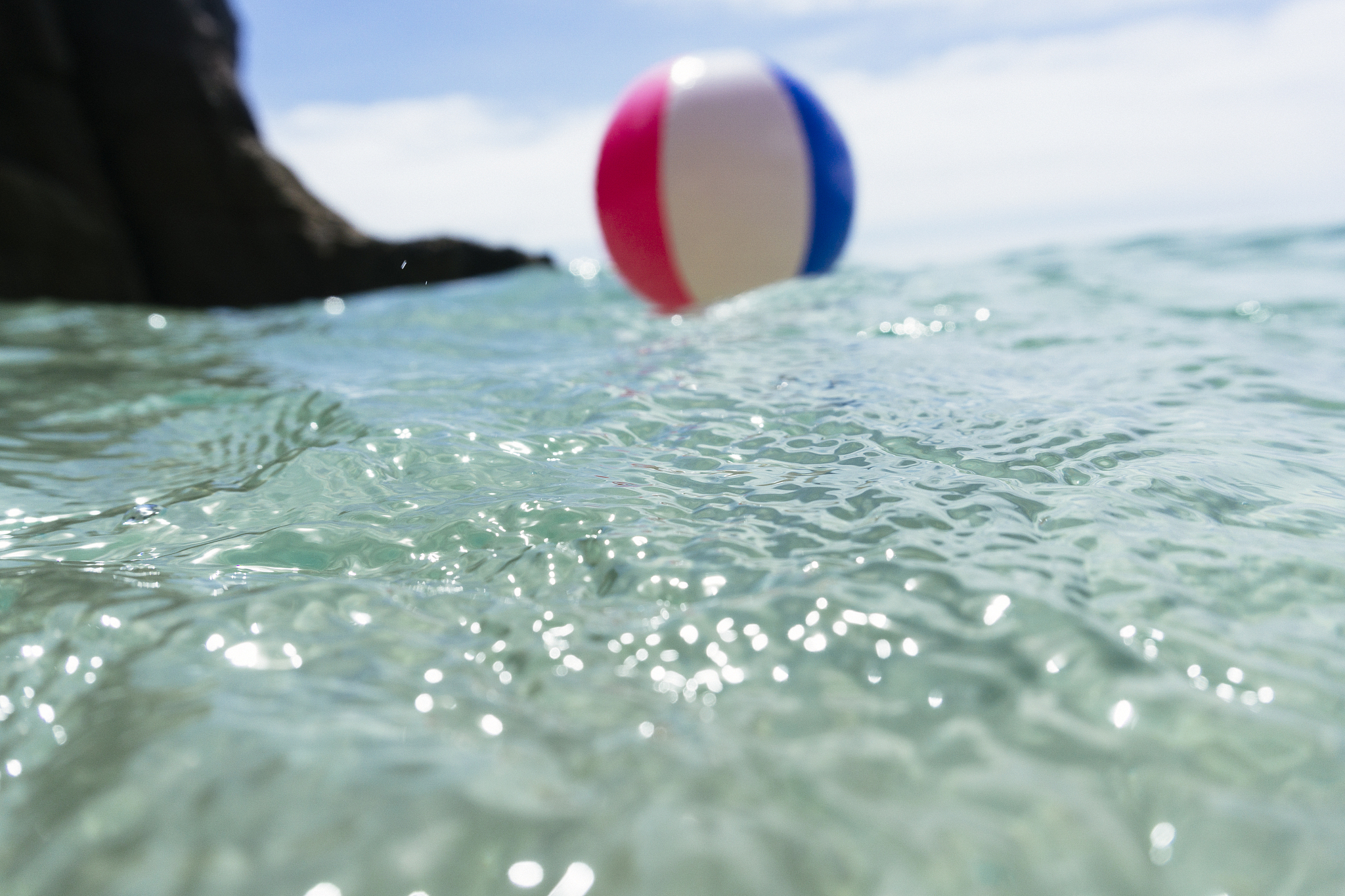 beach ball floating on clear blue sea, pedn vounder, cornwall