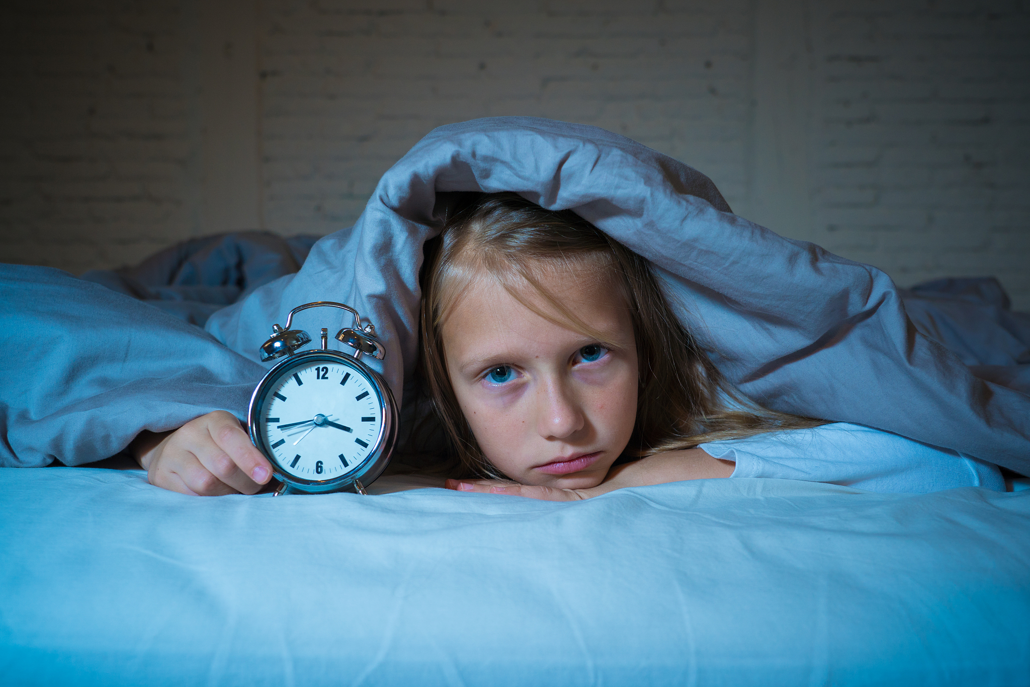 cute sleepless little girl in bed awake in the middle of the nig