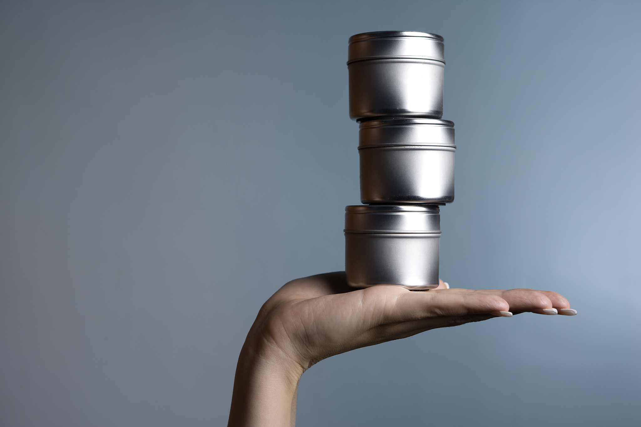 hand holding tin cans