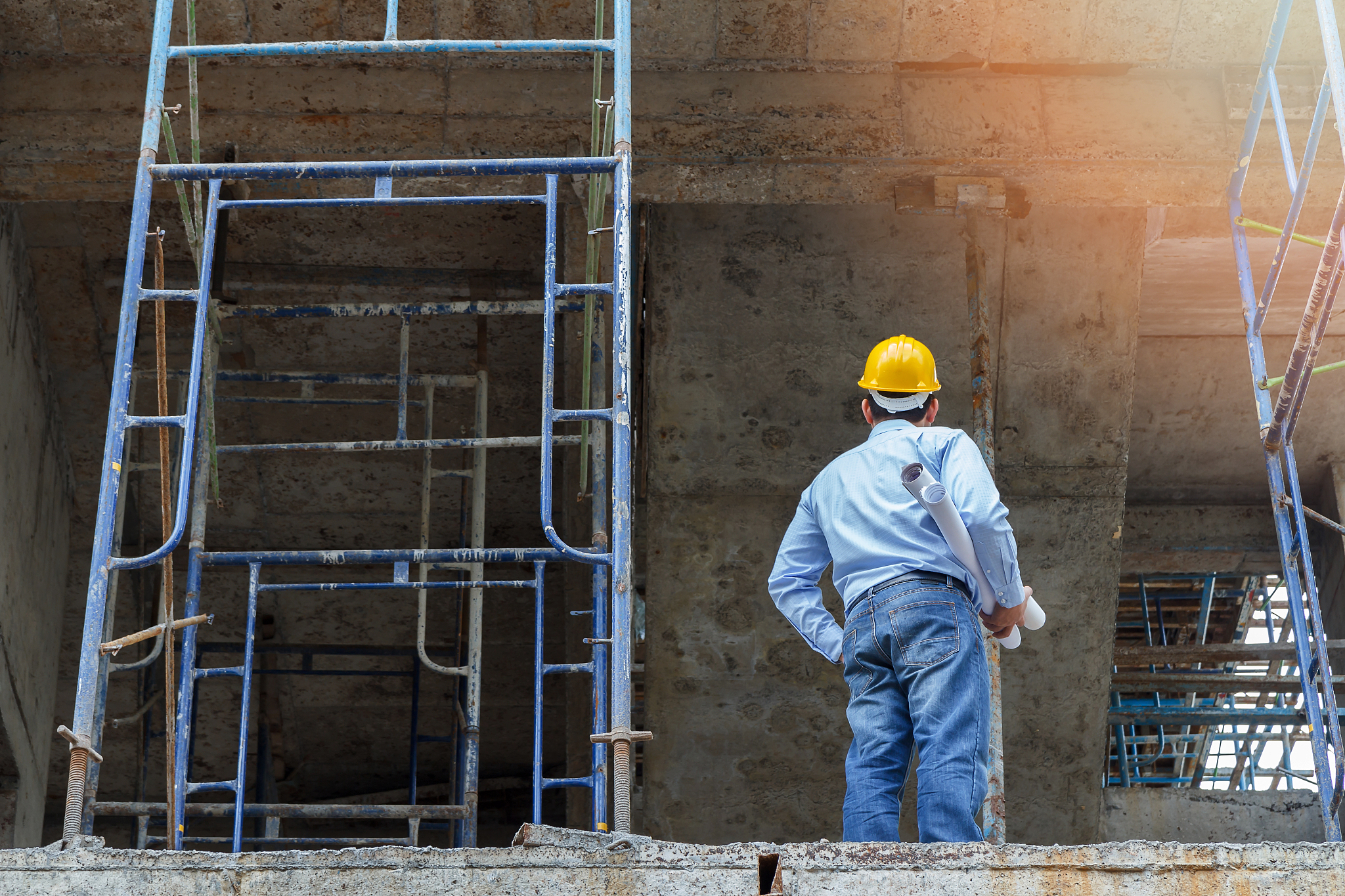 engineer with blueprint in building construction site