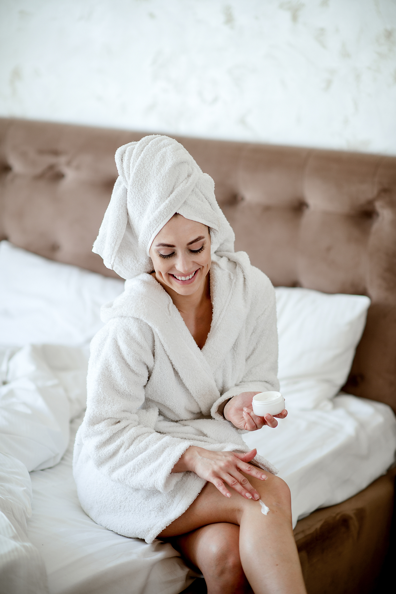 woman applying moisturizer to her legs