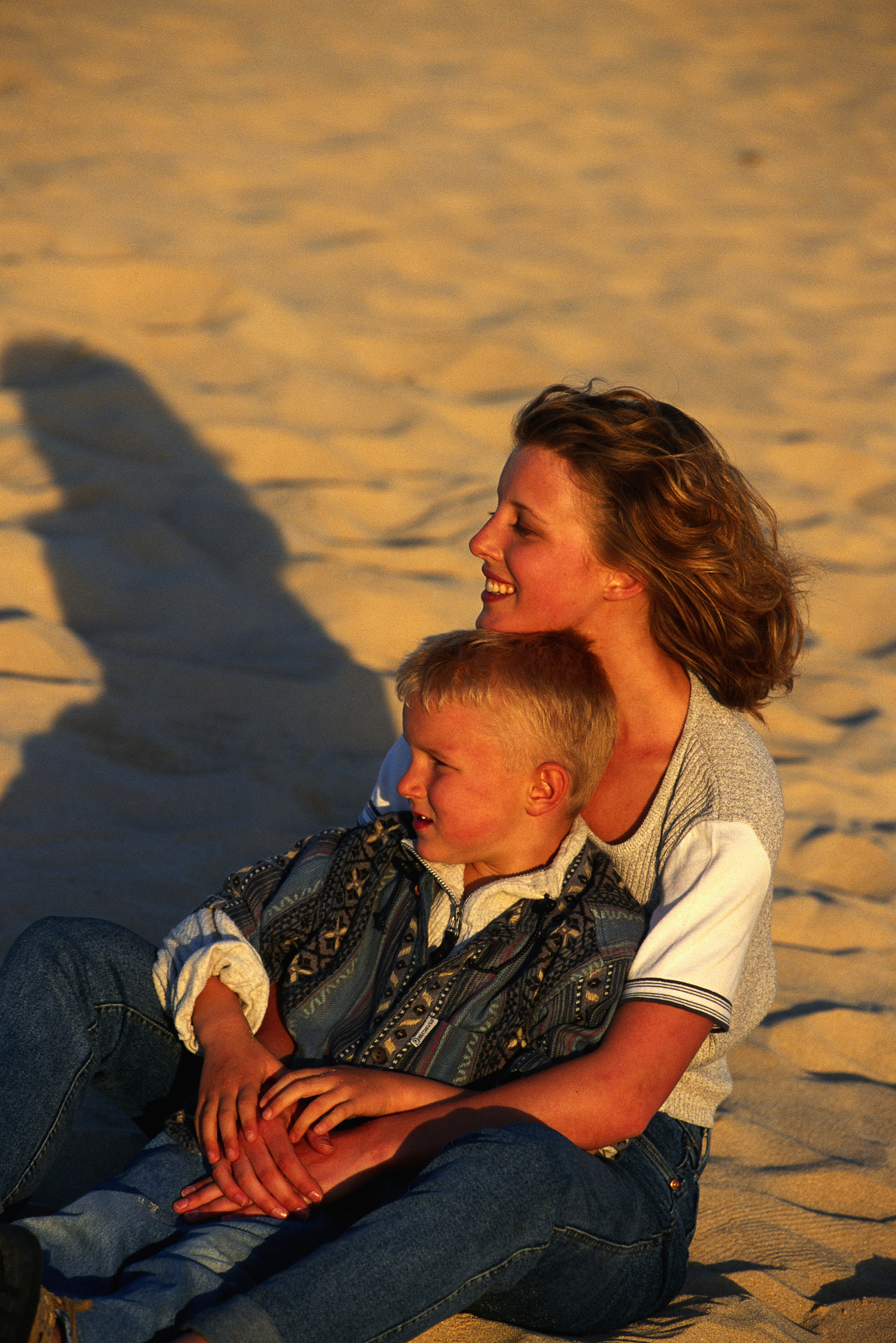 woman sitting in desert with son