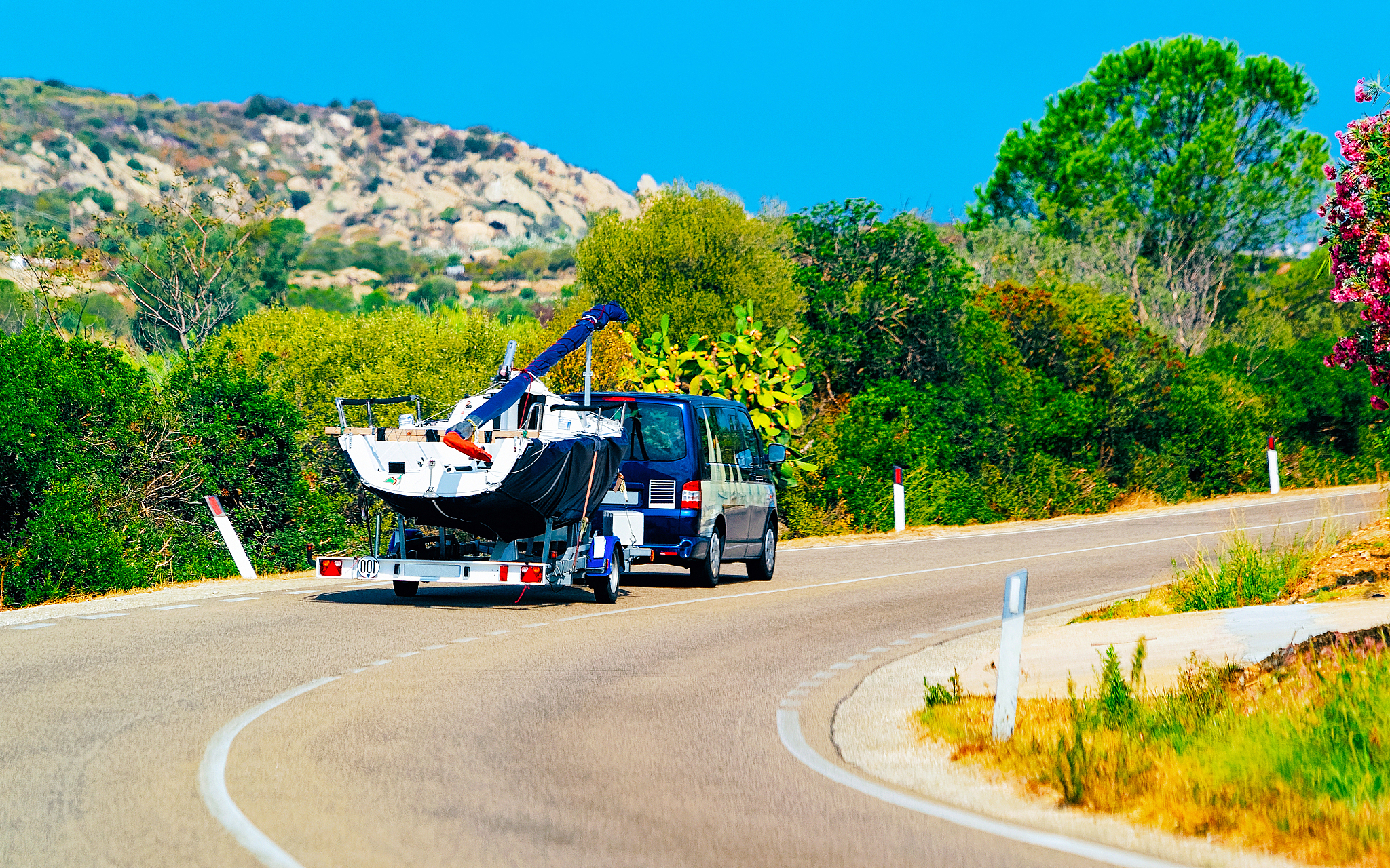 car with yacht or motor boat in road in sardinia