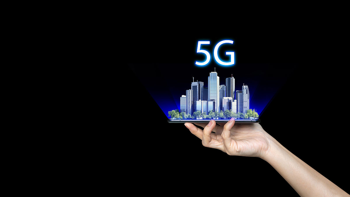 手持一部手机,背景是一个5g智能城市.5g网络,高速移动互联网,新一代网