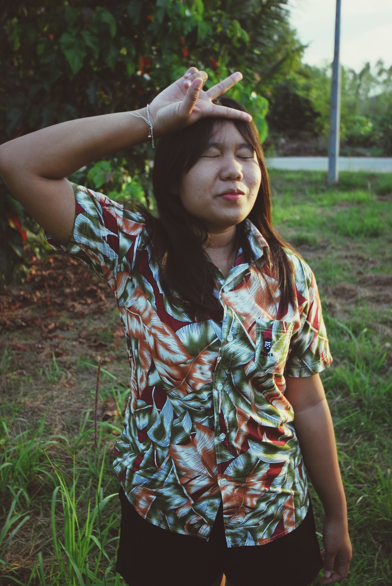 young woman showing peace sign on field