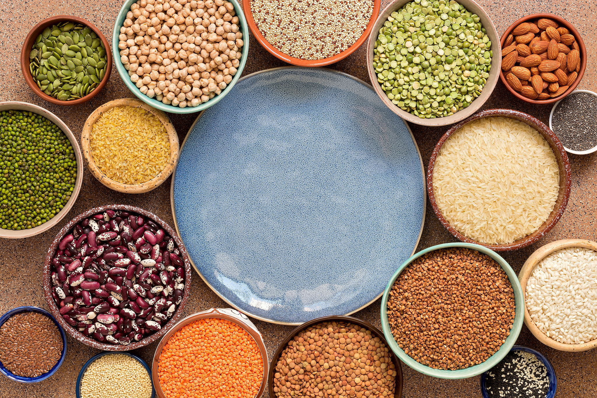 empty blue plate and frame of various legumes, grains, seeds in 