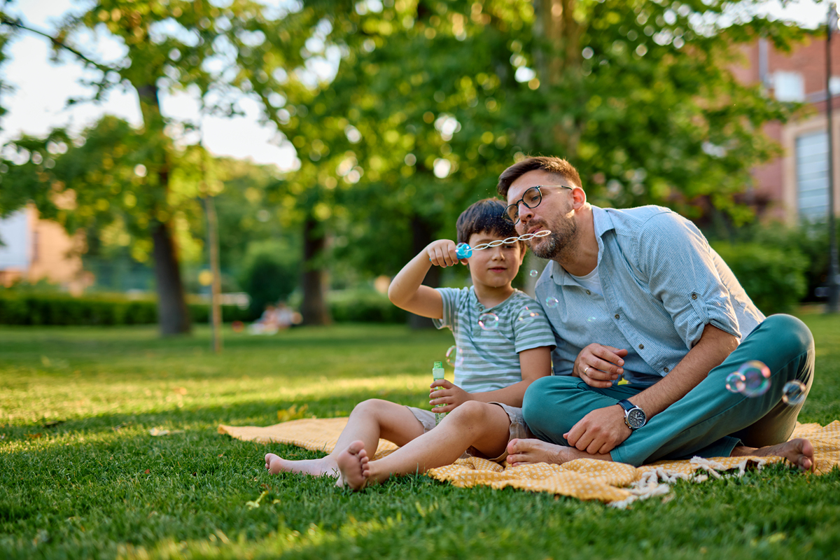 父亲节温馨照片：爸爸和儿子在公园的亲密合影