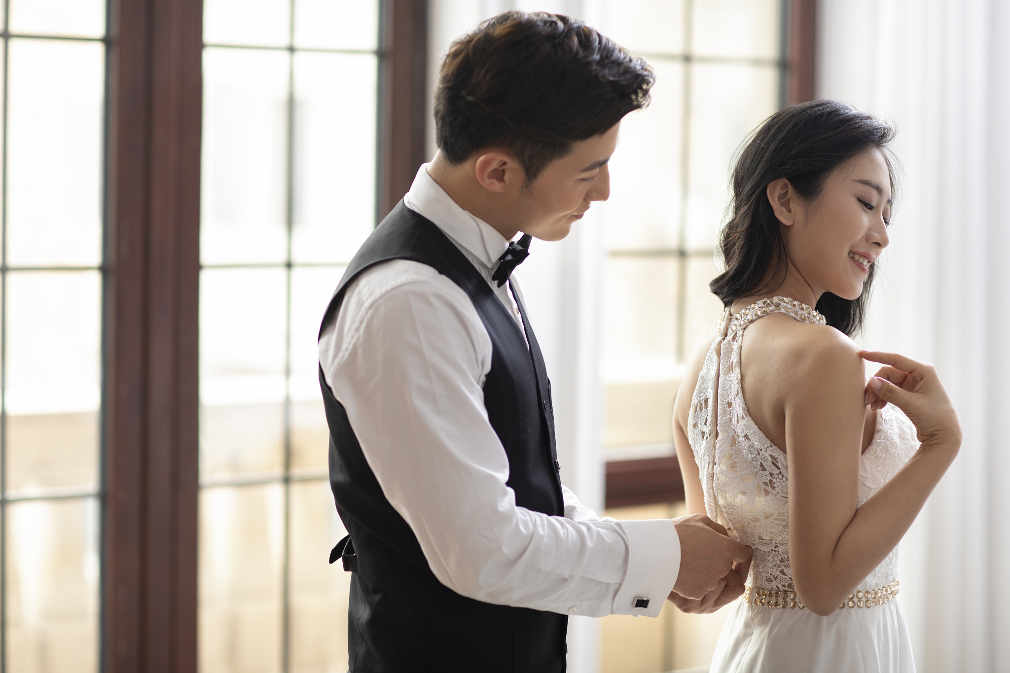 年轻男士帮妻子拉裙子拉链