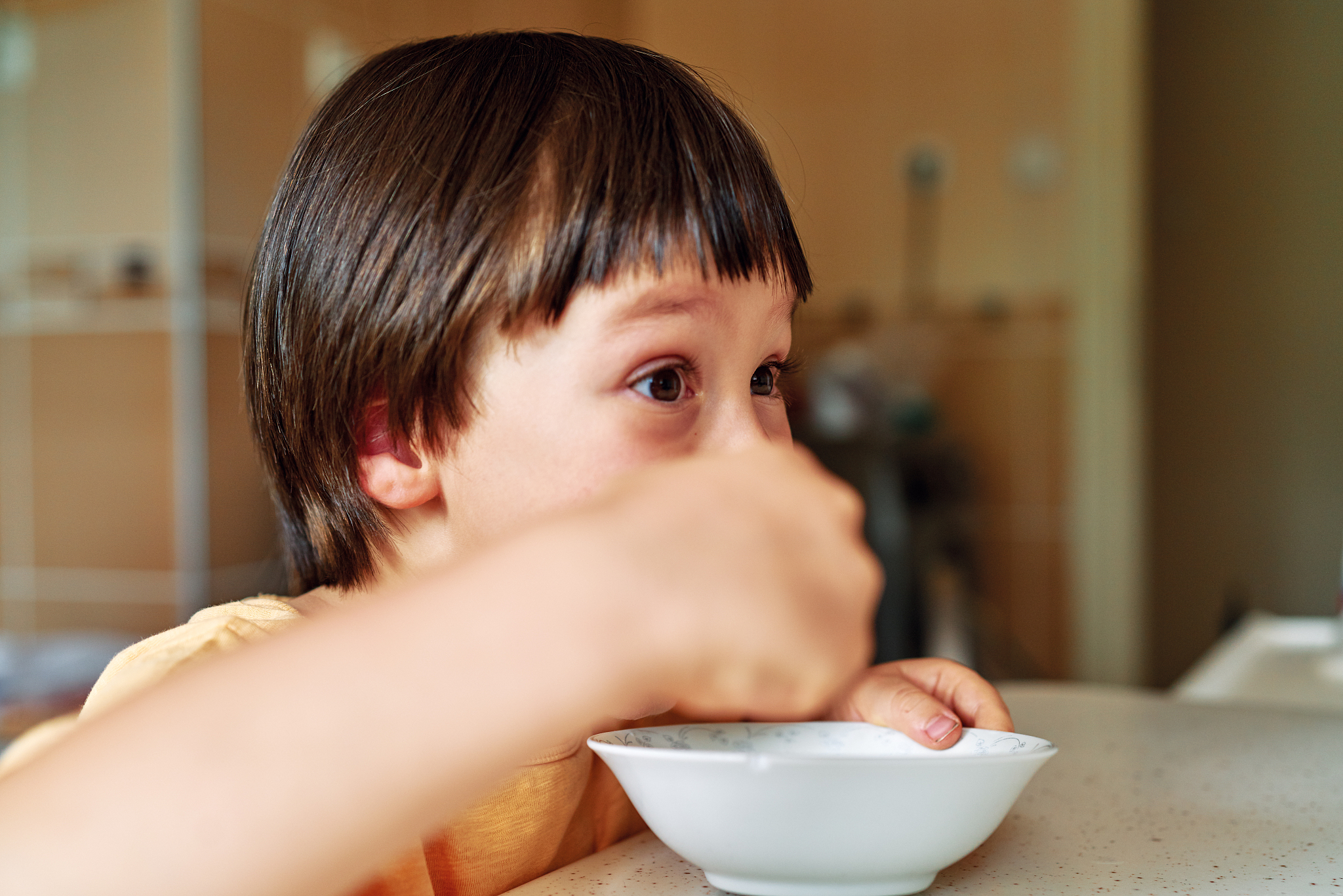4-5 years old cute child eating corn flakes with milk for breakf