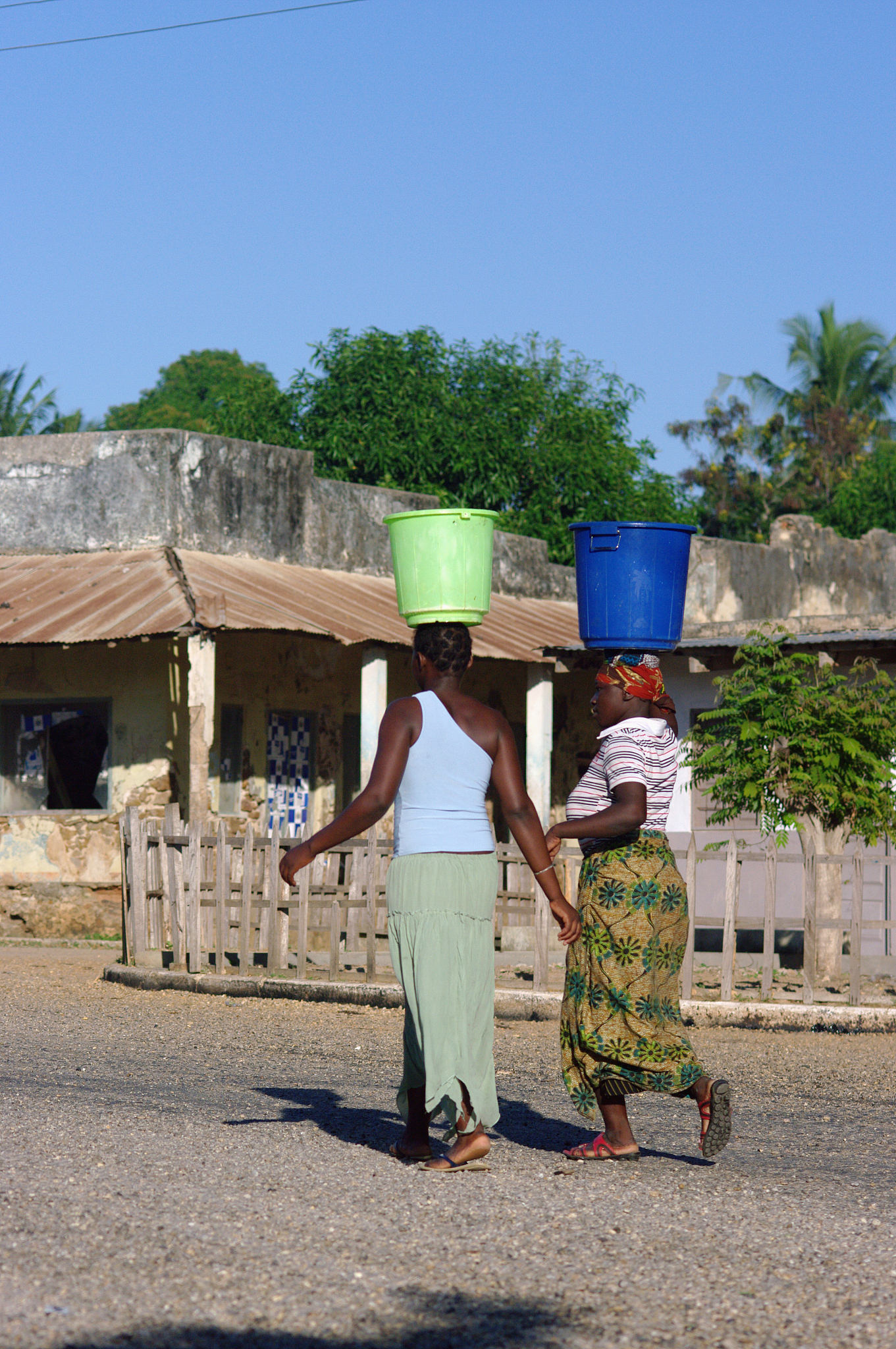 africa, mozambique, view of women carrying plastic buckets on he