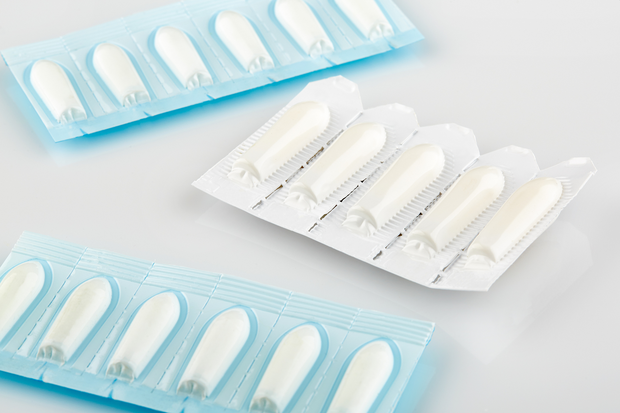 blue and white packages with suppository on white background