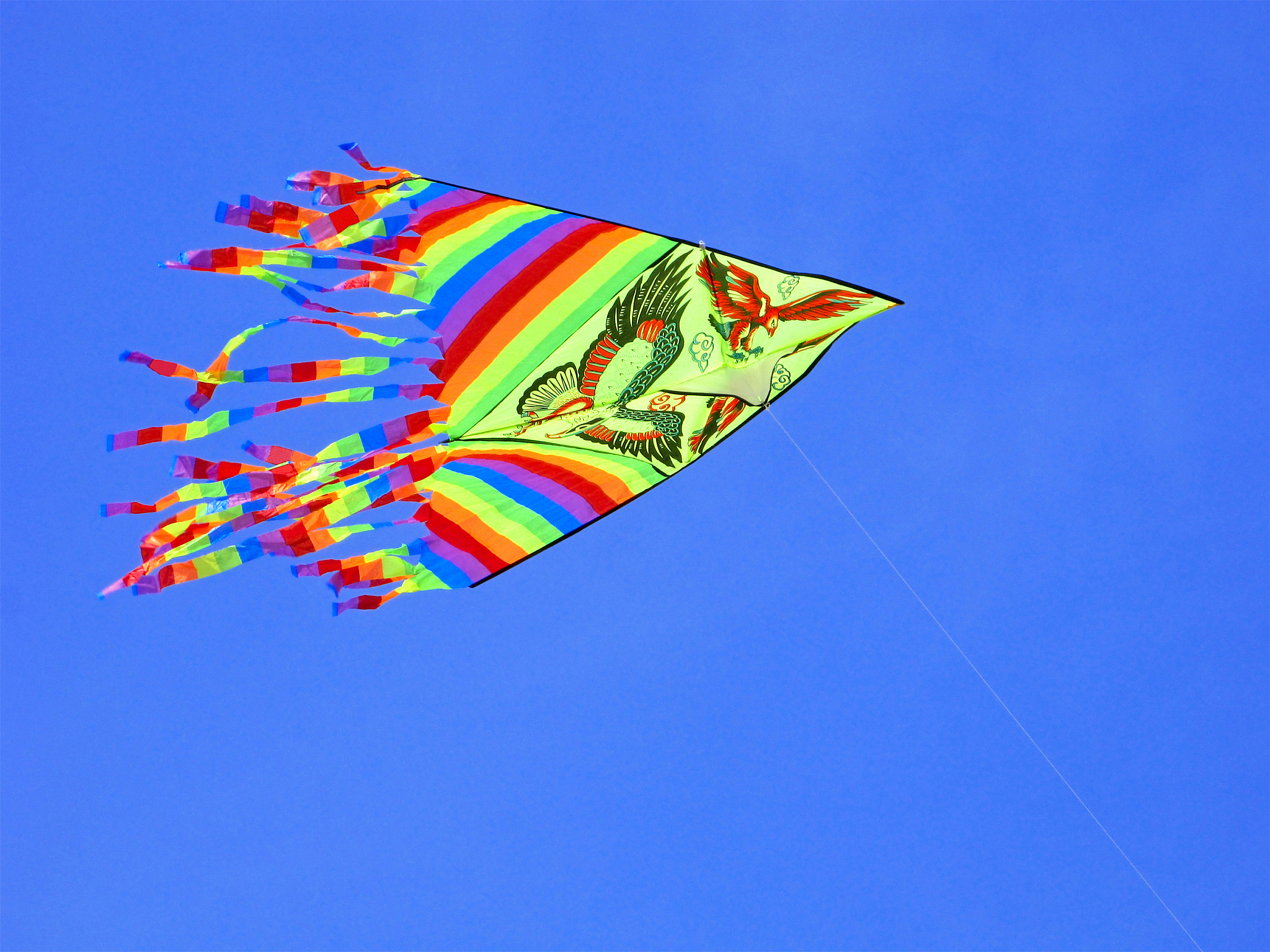 multicolored kite in a clear blue sky