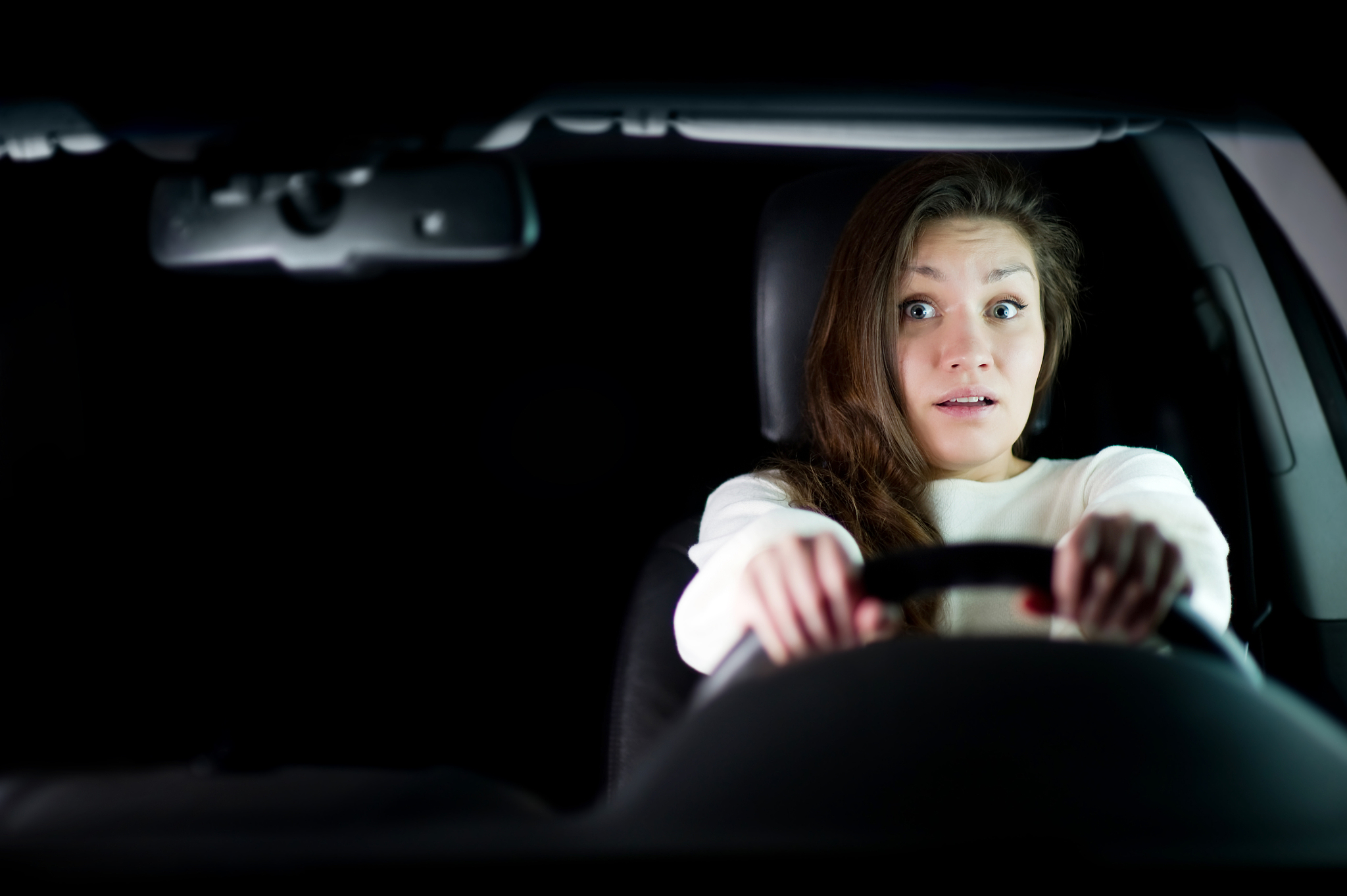 girl is afraid holding the steering wheel. copy space