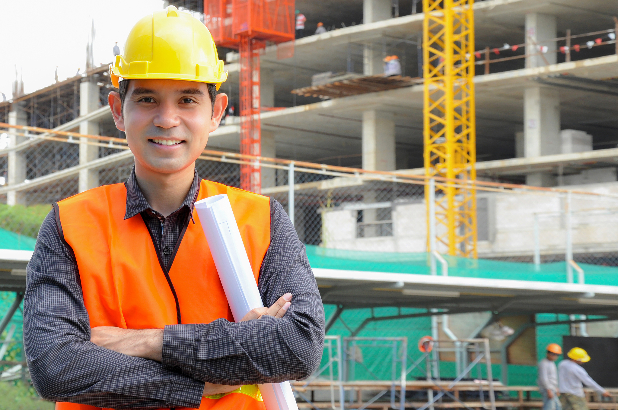 asian engineer or foreman in front of construction site
