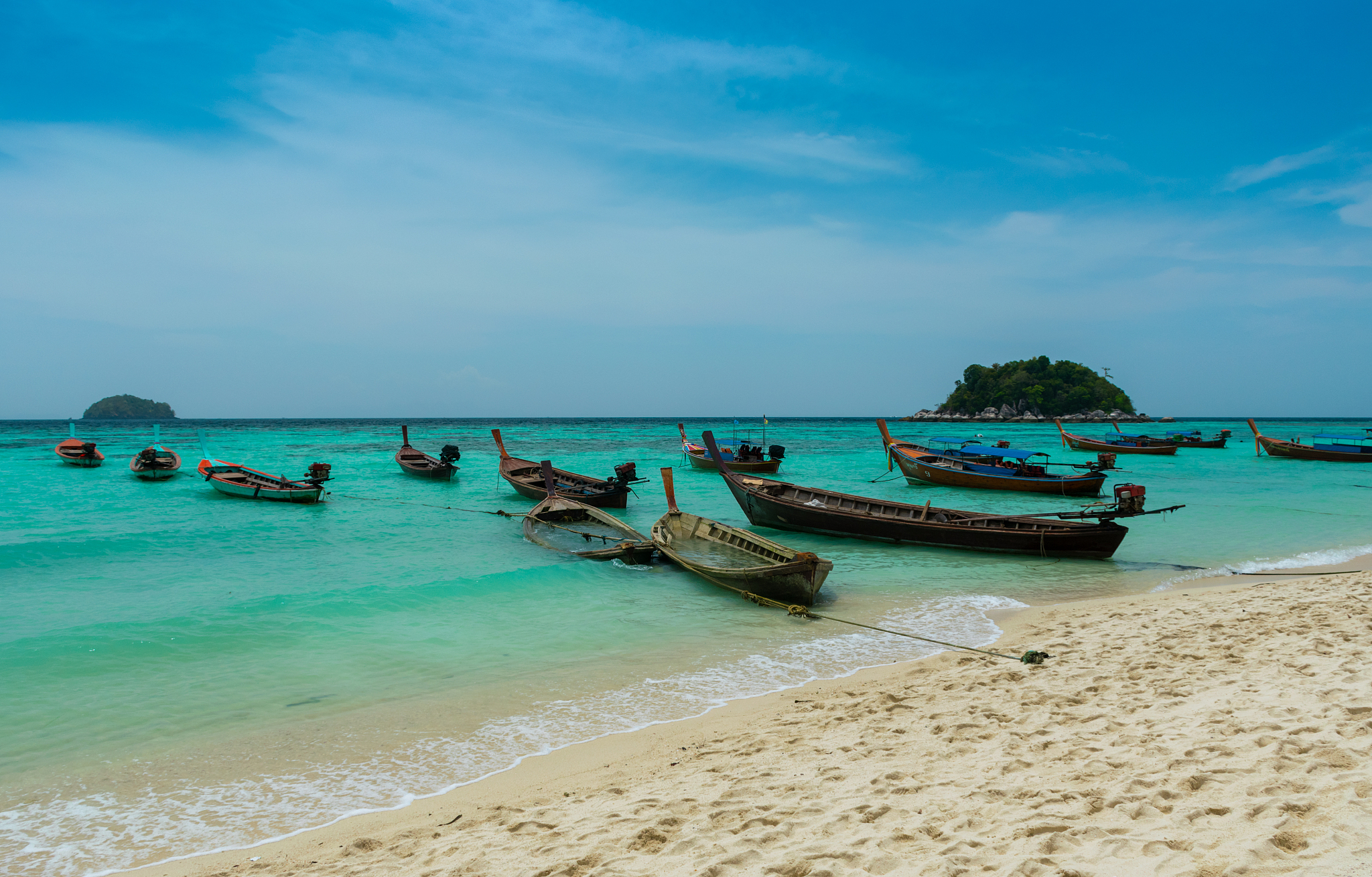 beautiful longtail boats on sea against sky at koh lipe, thailan