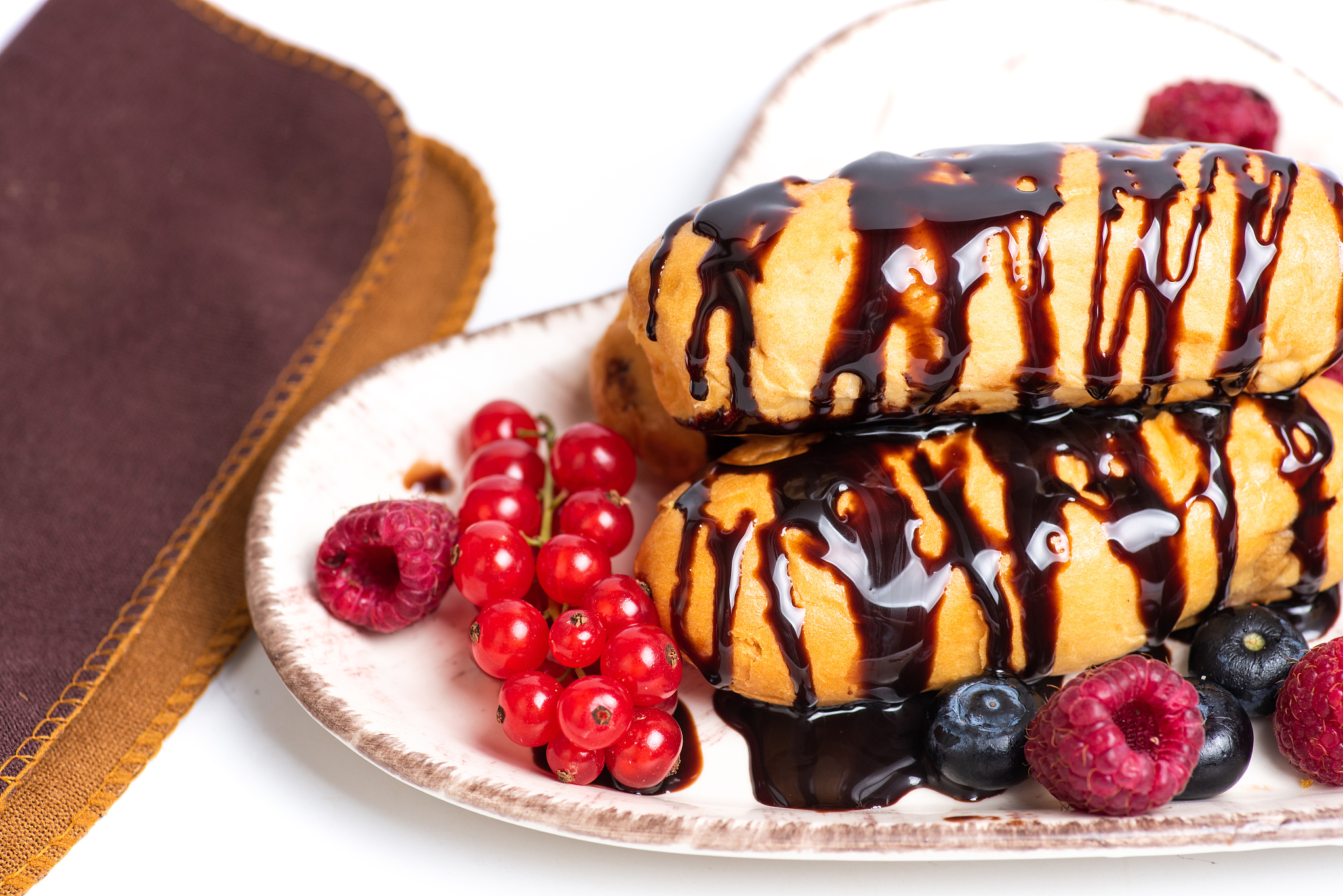 bun with chocolate cream and mixed berry fruit on a plate