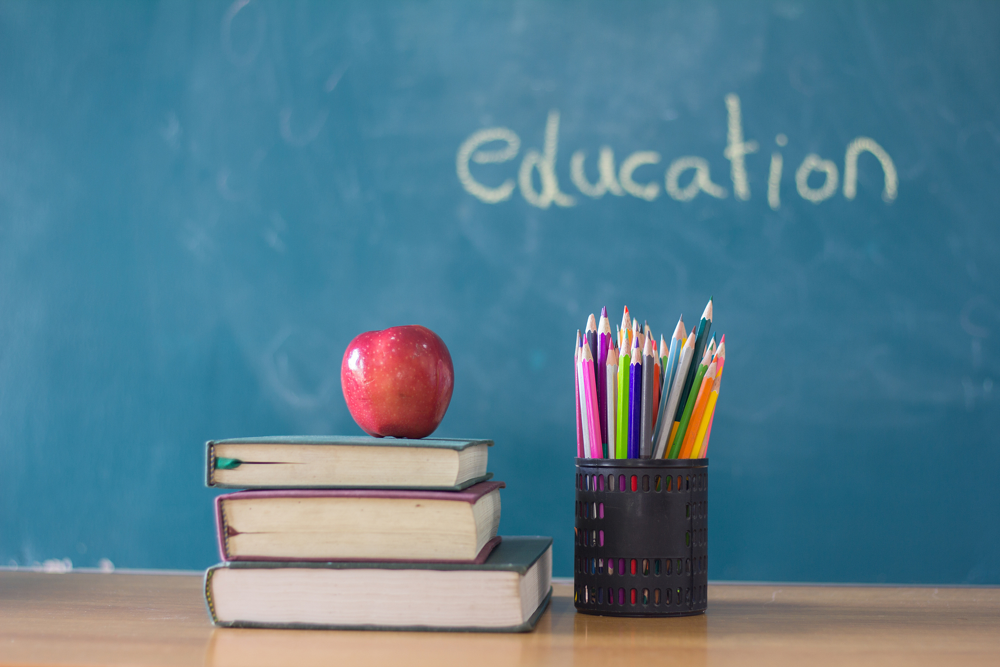apple puts on a book studying ,the background is blackboard, edu