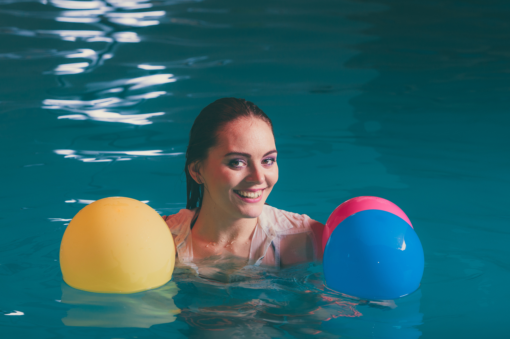 happy woman in water having fun with balloons