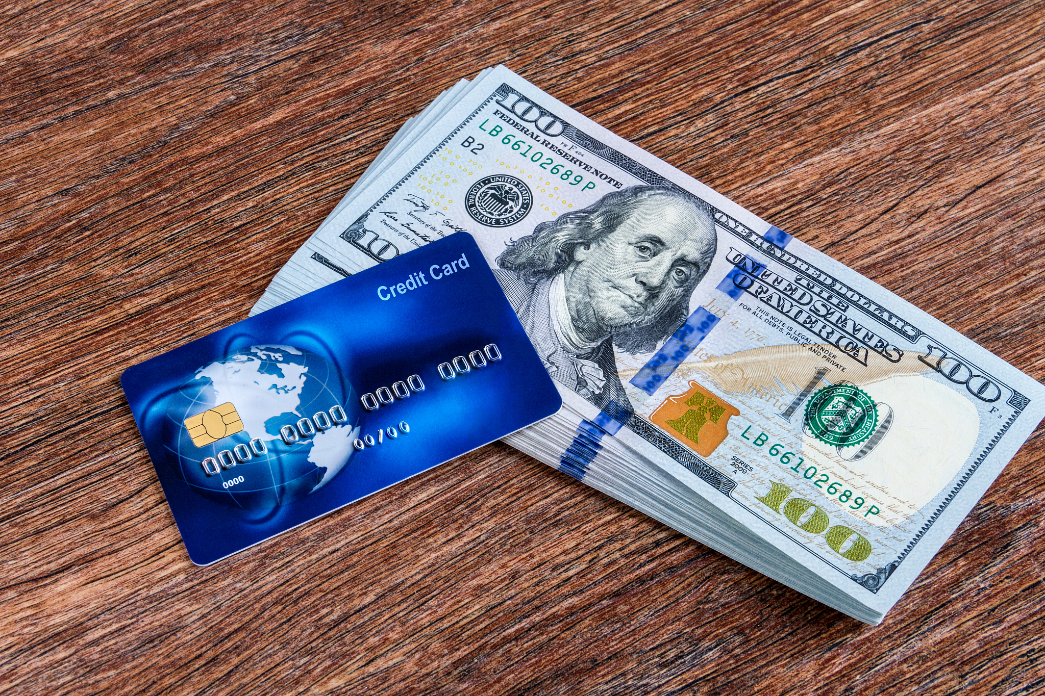 worldwide credit card and american dollars on wooden background