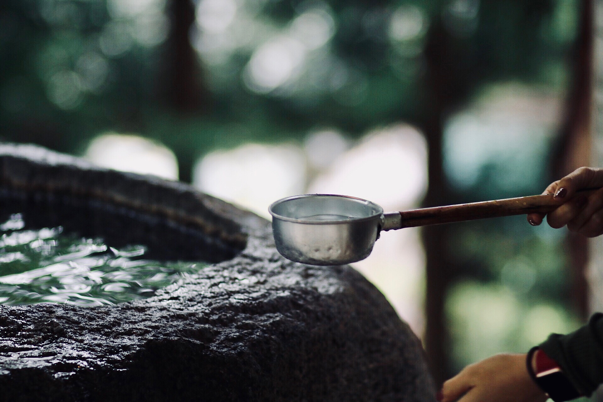 close-up of hand holding water in ladle
