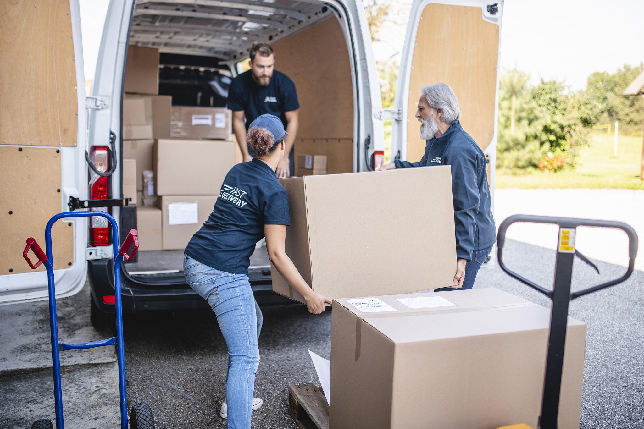 gig delivery team lifting packages onto van for transport