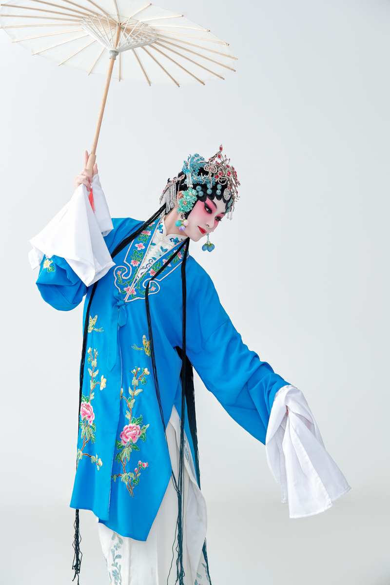 一位京剧女演员扮演青衣或花旦角色,手持油纸伞.