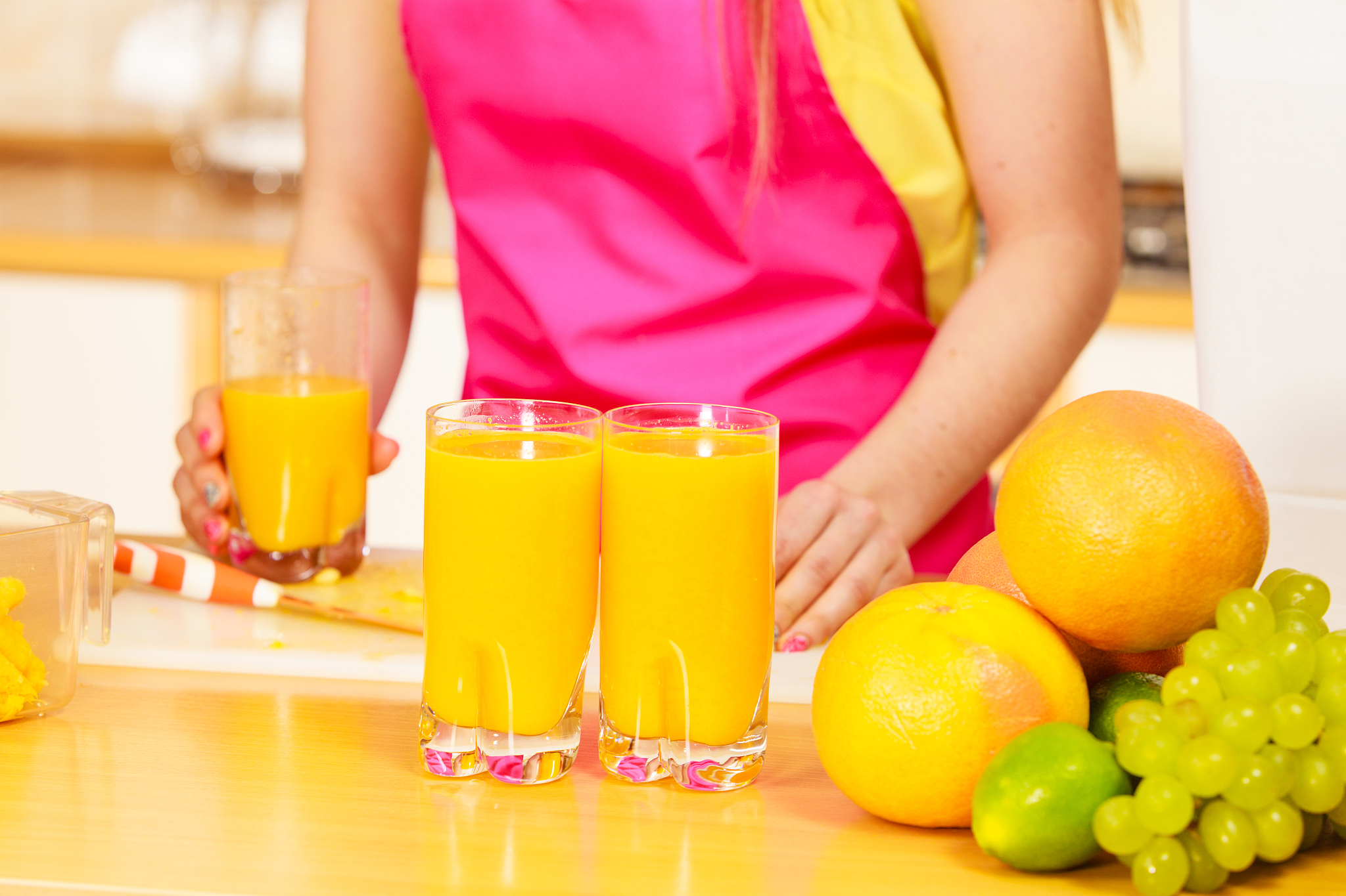 woman with fresh fruits and juice in kitchen