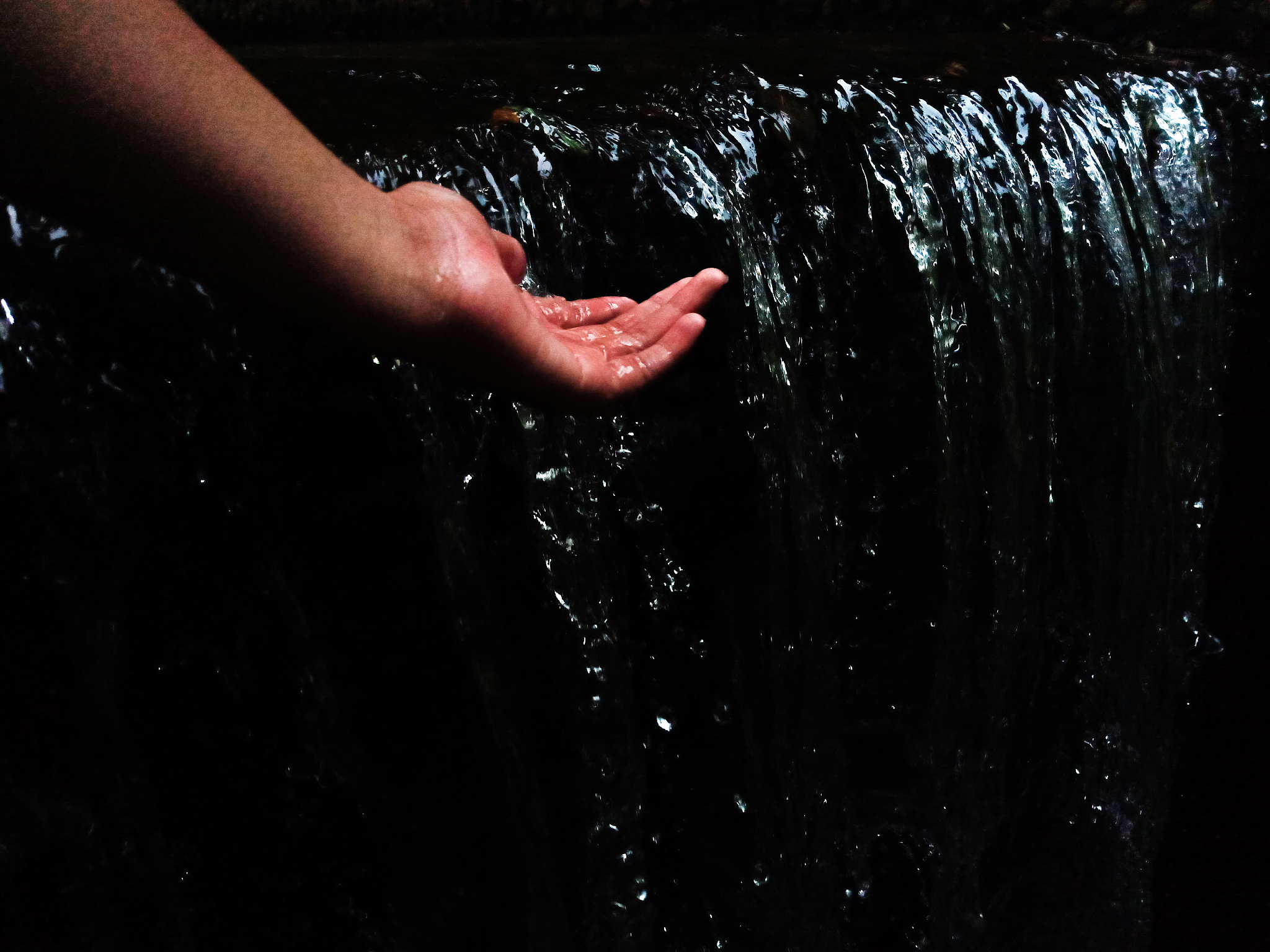 cropped image of person hand in water